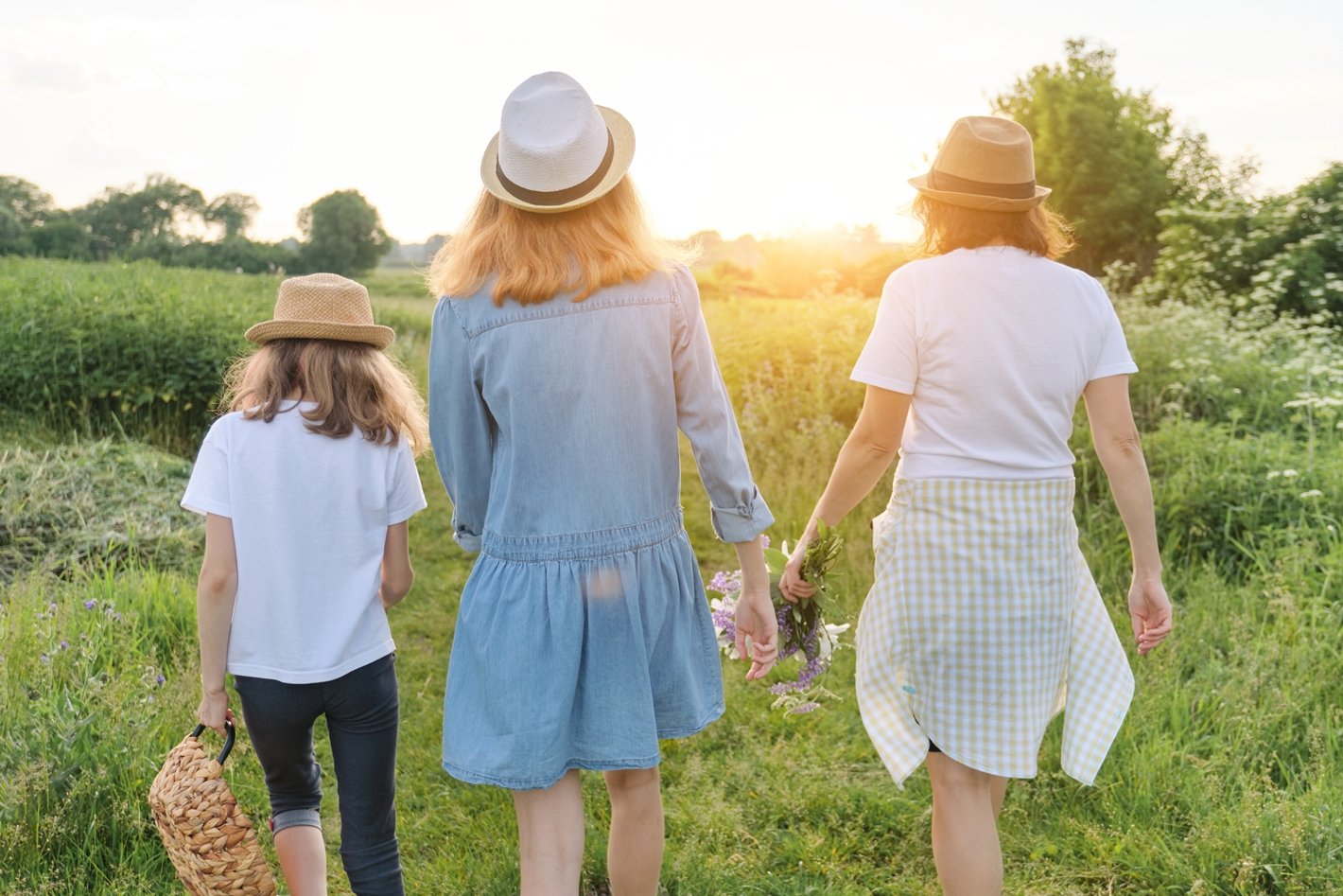 mother-with-two-daughters-walking-along-country-road-back-view